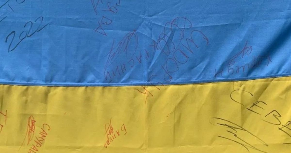 Волонтери «Новоград Допомагає» розігрують прапор України, підписаний захисниками Сєвєродонецька, для допомоги ЗСУ