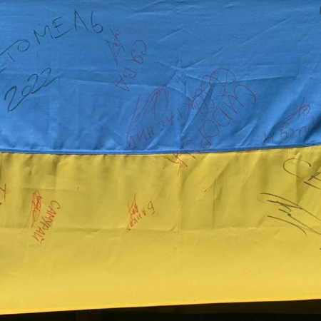 Волонтери «Новоград Допомагає» розігрують прапор України, підписаний захисниками Сєвєродонецька, для допомоги ЗСУ